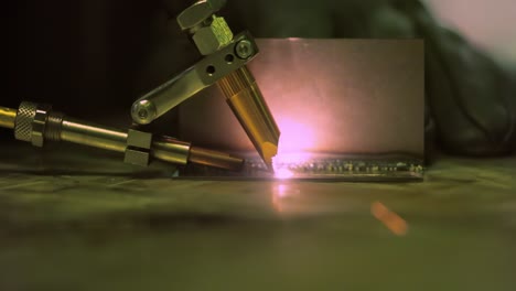Laser-welding-machine-with-hand-hold-gun.-Laser-welding-is-shown-in-close-up.