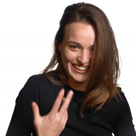 a beautiful model in a black jumper tilts her hair back and smiles on a white background in the studio. close-up.