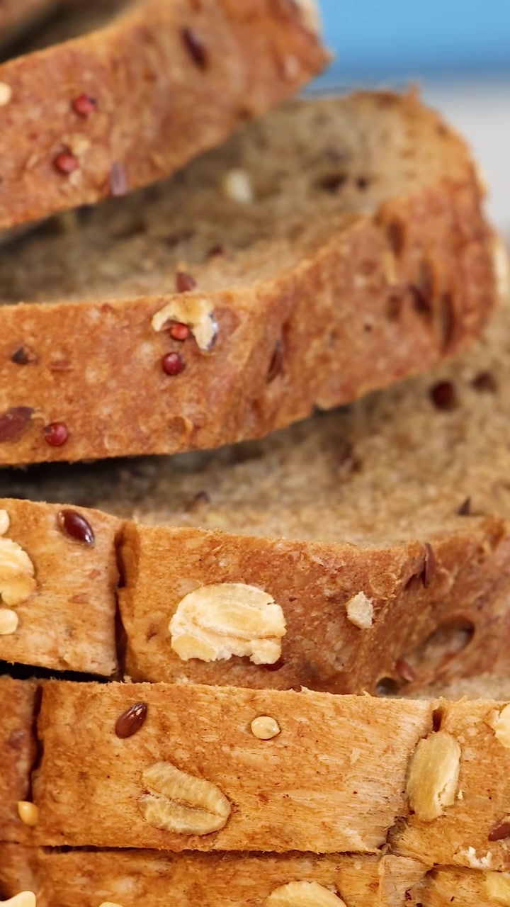 Viste ravvicinate di vari cereali, pani e pasta sotto un'illuminazione brillante. Enfasi sulla consistenza e sulla varietà.