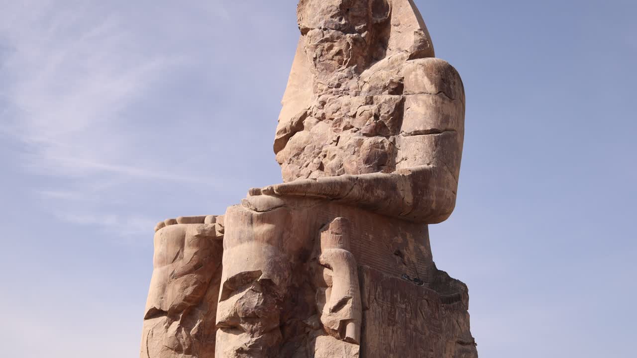 ruinas de la estatua gigante de faraón con montañas en el fondo en los colosos de memnon en luxor, egipto
