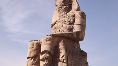 Ruinas-De-La-Estatua-Gigante-Del-Faraón-Con-Montañas-Al-Fondo-En-Los-Colosos-De-Memnon-En-Luxor,-Egipto.