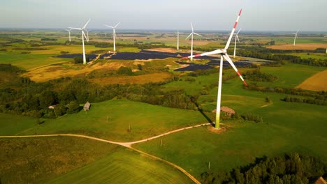 Aerial-footage-of-wind-turbines-in-a-wind-farm-generating-green-electric-energy-on-a-wide-green-field-on-a-sunny-day,-in-Taurage,-Lithuania