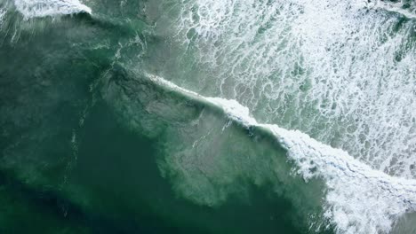 aerial - waves rolling out diagonally, beautiful patterns of whitewash and sandy bottom being disturbed