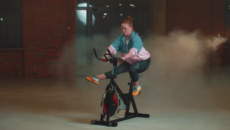 Mujer-Caucásica-Sana-Haciendo-Ejercicio-En-Bicicleta-Estacionaria-En-Bicicleta-En-El-Gimnasio,-Cámara-Lenta