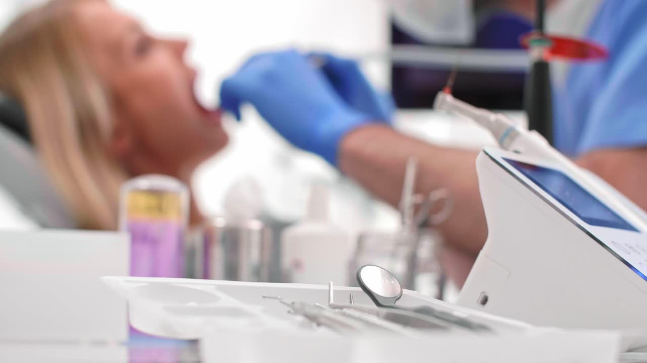 Focused dentist with dental drill cleaning bad patient's teeth