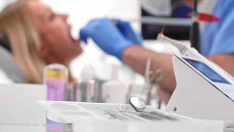 konzentrierter zahnarzt mit zahnbohrer reinigt die zähne eines schlechten patienten