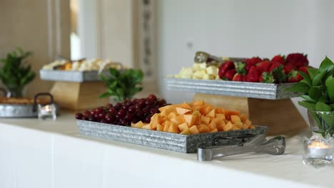 cheese, grapes, and fruit platter on display at wedding reception food table