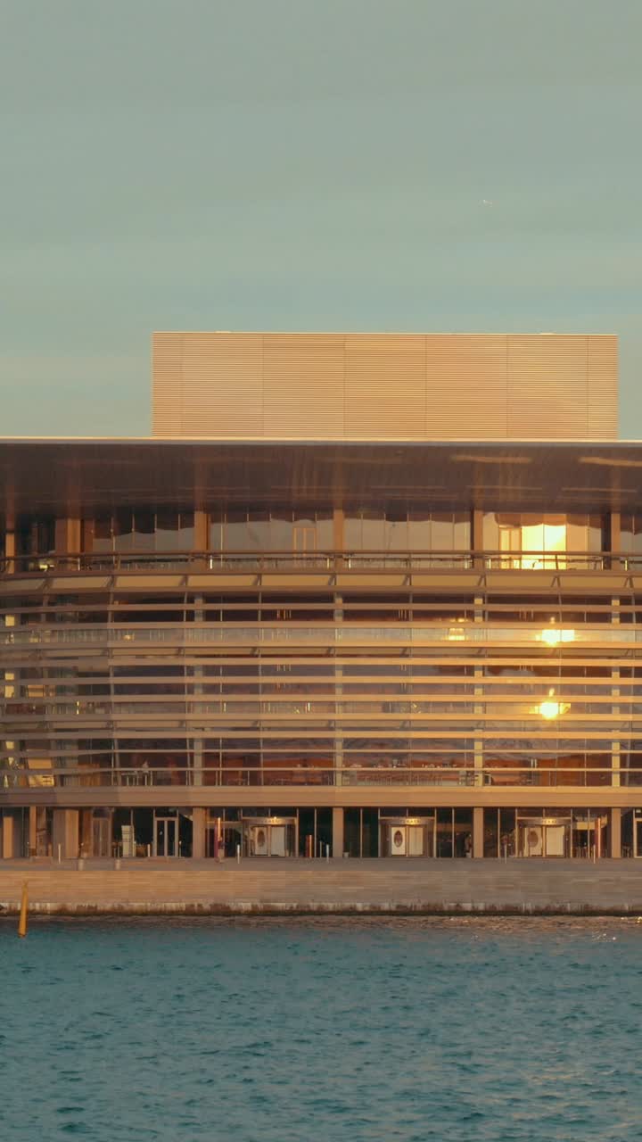 Sol da Hora Dourada Refletindo em Edifício Moderno à Beira-Mar