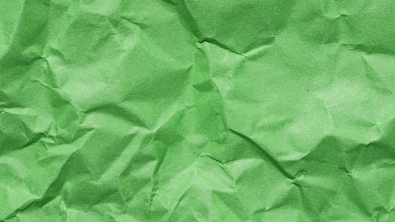Stop motion animation of crumpled green paper, creating a continuous looping textured background