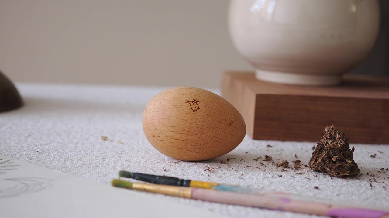 Wooden Egg with Small Engraved Bird Symbol on Artist Table