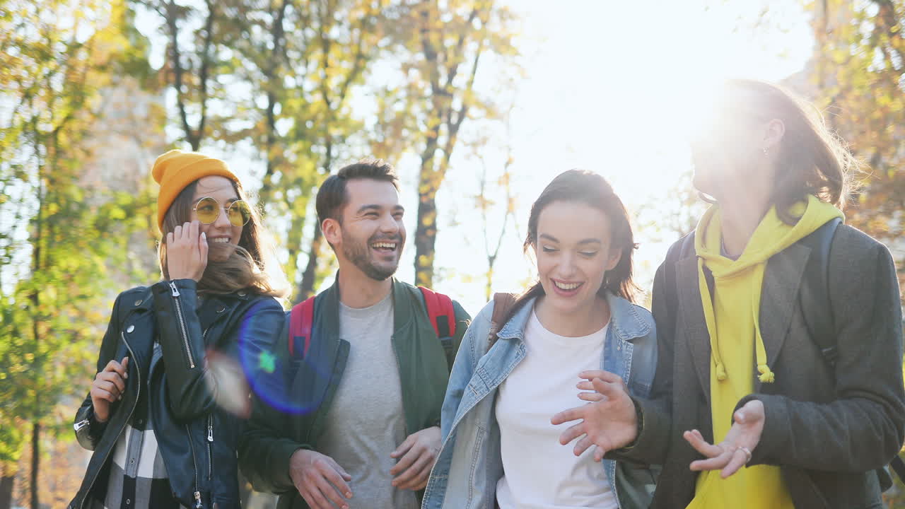 가을에 공원에서 걷고 이야기하는 젊은 친구들