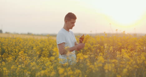 Joven-Agricultor-Con-Tableta-Digital-Agricultor-Agrícola-Que-Controla-El-Crecimiento-De-Las-Plantas