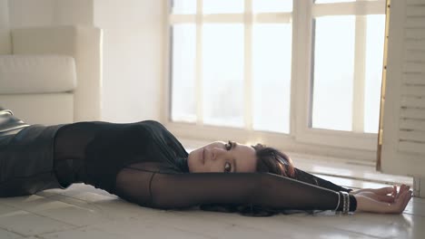 attractive girl lies on floor and stands up in modern room