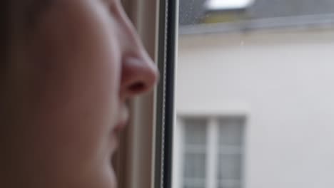 a close-up of a woman’s face as she gazes out of the window - defocused shot