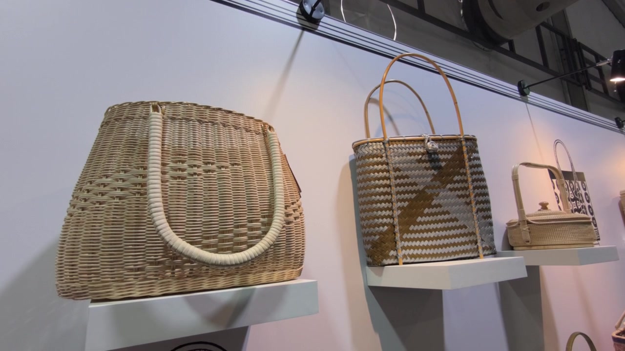 Moderni manufatti intrecciati realizzati con rattan e foglie di pandano sono esposti a una mostra di artigianato. Colori vivaci e design freschi valorizzano questi tradizionali articoli tessuti malesi.