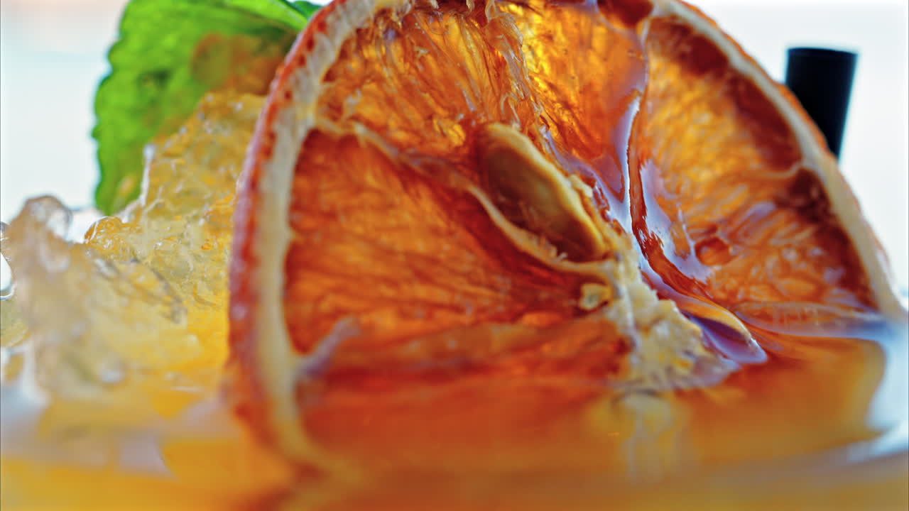 Close up of an orange cocktail on a table with a blurred view of the sea on the background