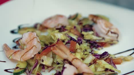 cook pours a salad with shrimp sauce 1