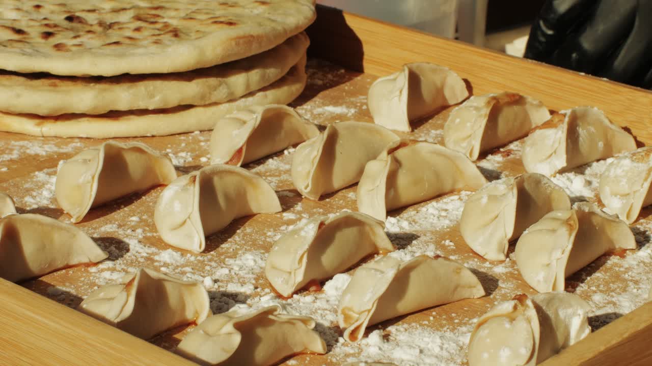 Chinese and Japanese Jiaozi or gyoza on wooden desk close-up. Dumplings with meat pouring red sweet chilli sauce. Cooking at cafe, restaurant. Asian street food market outdoors.High quality 4k footage