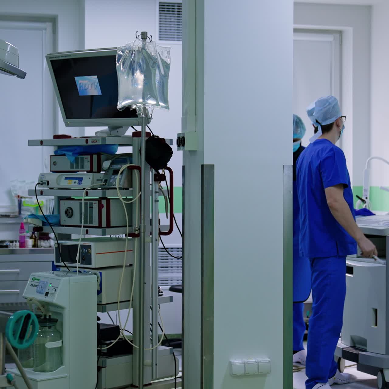 Cirujanos consultando y mirando una radiografía. Los médicos señalan la película y luego entran en el quirófano.