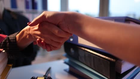 lawyer shakes hands with client in courtroom closeup