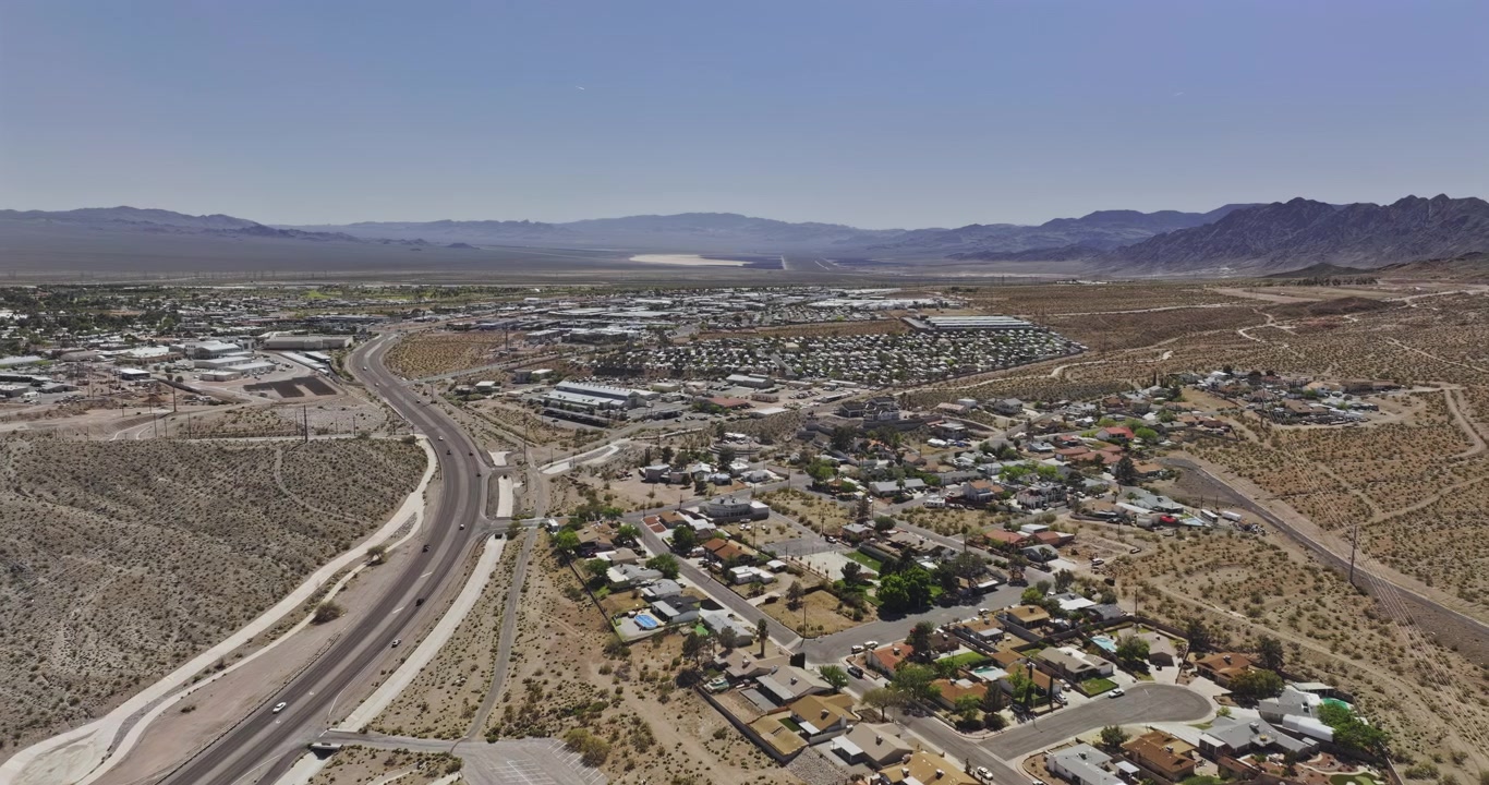 Boulder City, Nevada. Survol aérien ascendant v11 au-dessus des quartiers et du paysage urbain, révélant un terrain de lac asséché et les montagnes environnantes - Filmée avec un Mavic 3 Pro Cine - 16 avril 2024.