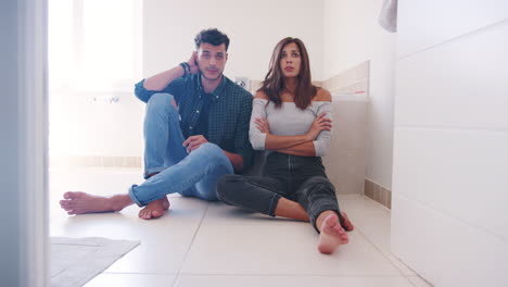 couple waiting for result of home pregnancy test in bathroom