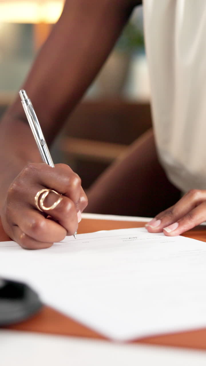 Primo piano di una donna afroamericana che firma un documento ufficiale