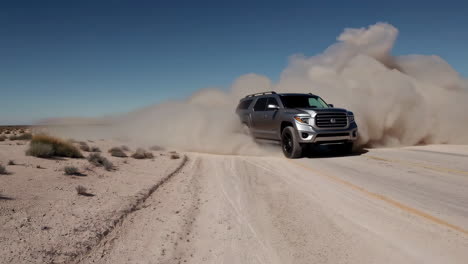 truck driving through dusty desert road
