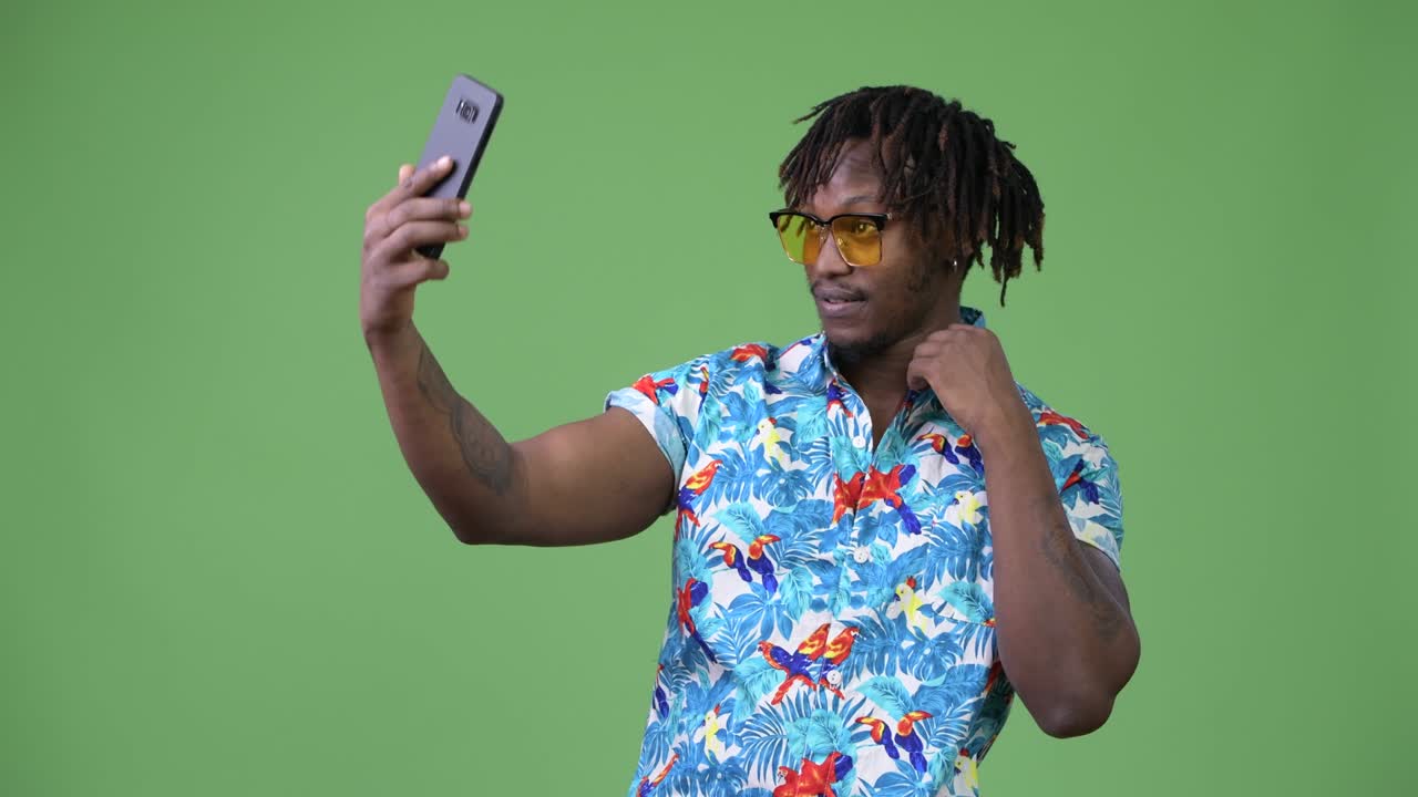 Young handsome African tourist man taking selfie