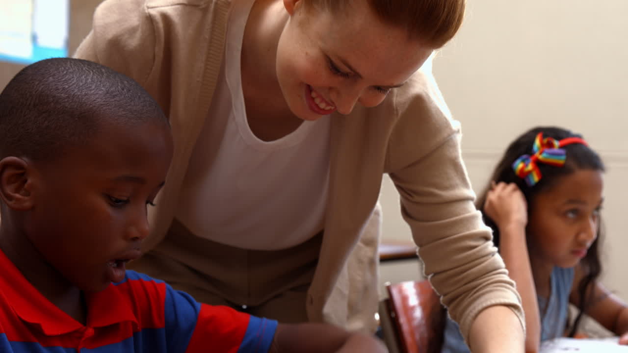 maestra ayudando a un niño pequeño durante la clase