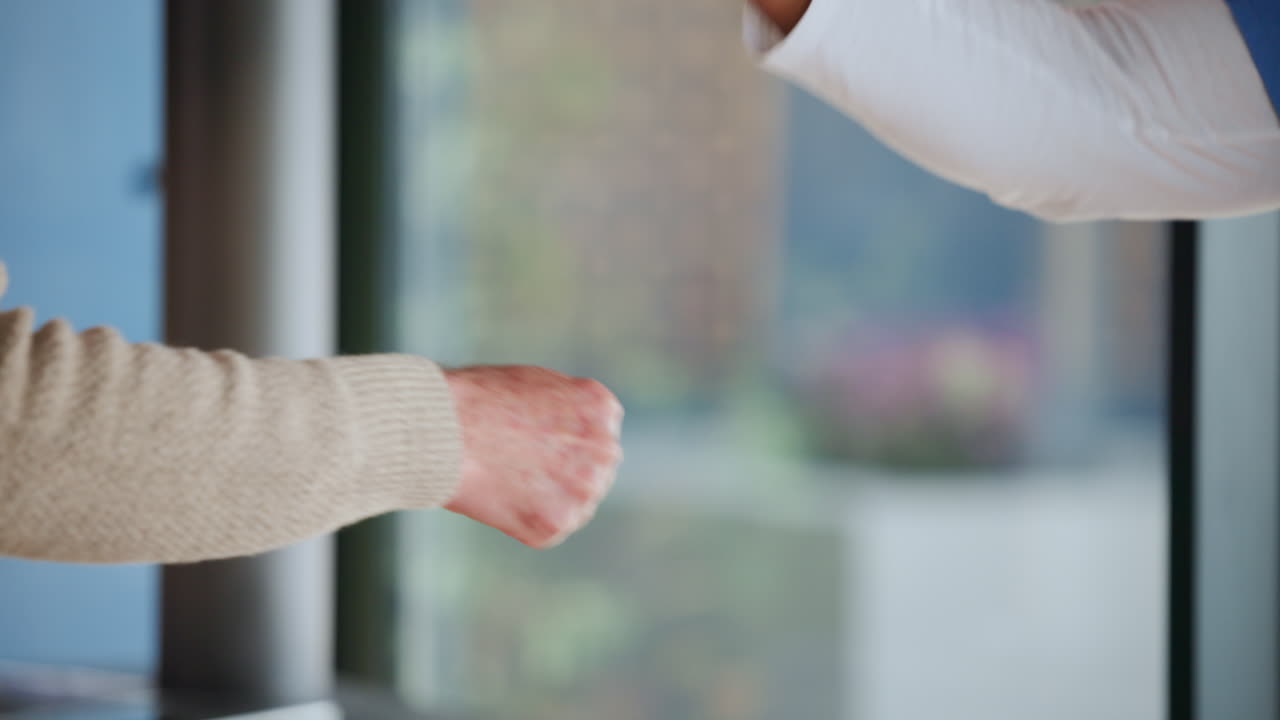 2人の人物が友好的にフィストバンプであいさつを交わしている