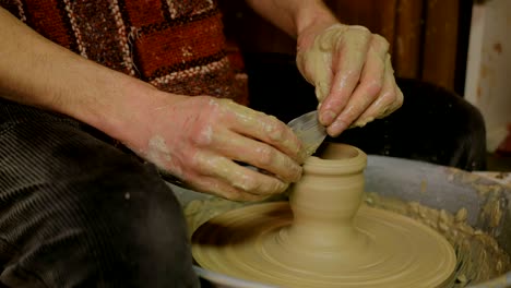 taza de conformación de alfarero profesional con herramienta especial en taller de cerámica