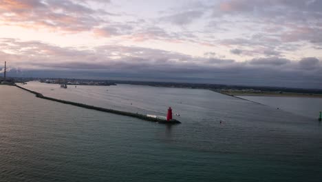 aerial view of a lighthouse at sunset near an industrial port