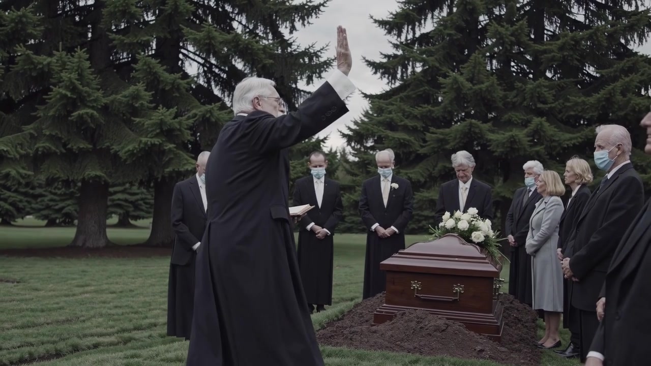 Ecclesiastico che celebra un funerale al cimitero