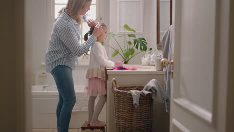 Feliz-Madre-Cepillando-El-Cabello-De-Su-Hija-En-El-Baño.-Una-Linda-Niña-Preparándose-En-La-Mañana.-Mamá-Amorosa-Disfrutando-De-La-Paternidad-Cuidando-A-Su-Hijo.