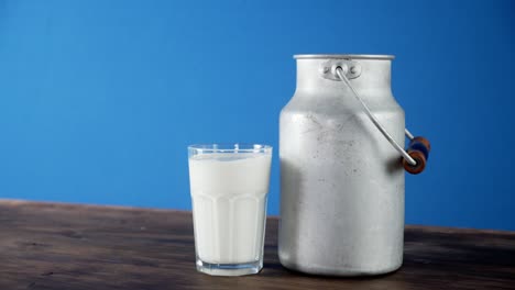 una lata y un vaso de leche giran lentamente sobre la mesa.