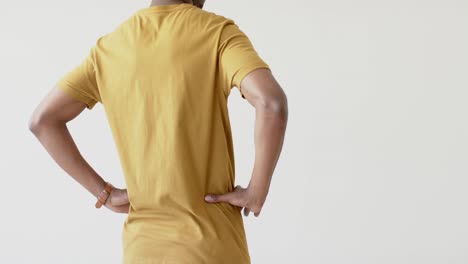 Midsection-of-african-american-man-wearing-yellow-t-shirt-with-copy-space-on-white-background