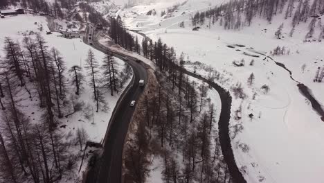 Vista-Aérea-De-Una-Carretera-A-Través-De-Montañas-Nevadas-En-El-Valle-D&#39;aosta,-En-Los-Alpes-Italianos,-En-Invierno