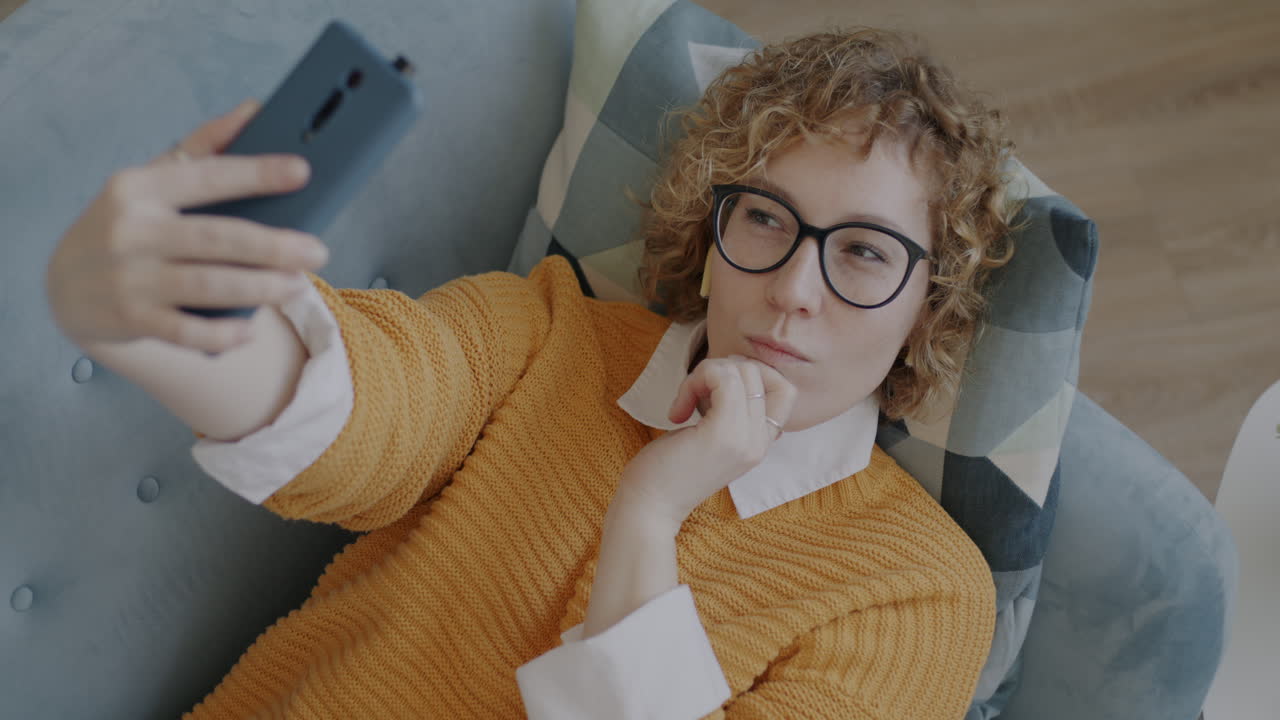 Woman Taking a Selfie on a Couch