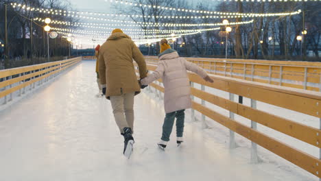 family ice skating at an outdoor rink