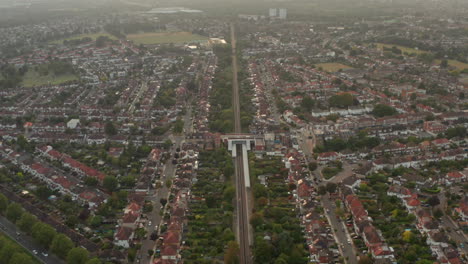 Toma-Aérea-Del-Tren-Que-Pasa-Por-Un-Amplio-Barrio-Residencial.