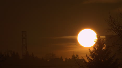 sol brillante levantándose lentamente brillando a través de las nubes al amanecer - toma estática