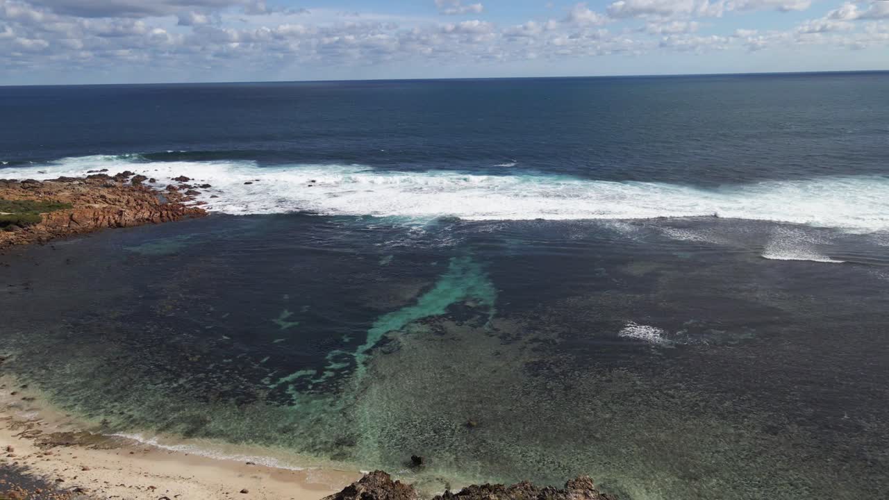 Volo aereo dalla terra all'oceano con le onde che si infrangono.