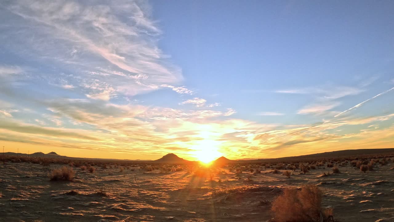 Driving through the Mojave Desert during a golden sunset - romantic view from the passenger window
