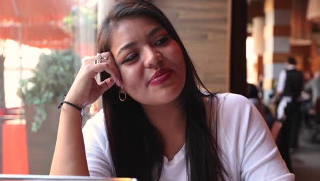 Positive-beautiful-girl-in-cafe-hanging-out-and-talking-with-great-energy-and-vibes