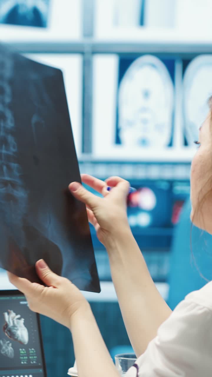 Female Doctor Examining X-Ray Scan and Working on Laptop