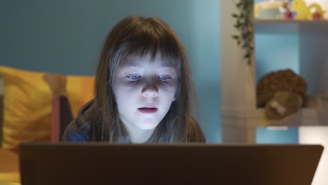 Niña-Mirando-Una-Computadora-Portátil-En-La-Habitación-De-Noche.-Adicción-A-La-Tecnología.