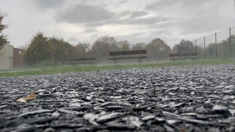 low static shot of a pathway in a park durning a thunderstorm, showing the grey sky