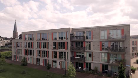 aerial reveal showing dutch residential urban development and infrastructure of noorderhaven neighbourhood in zutphen, the netherlands, seen from above with rooftops full of solar panels