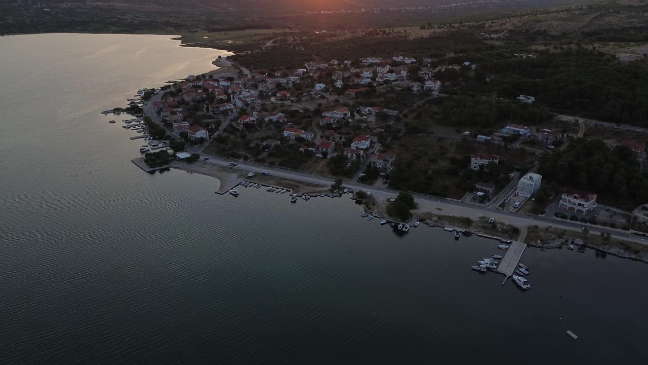 drone amanecer sobre el pueblo costero griego: montañas y barcos en el resplandor de la mañana